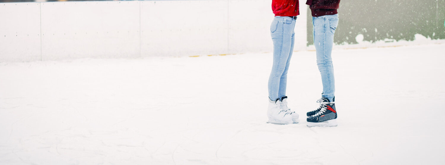 Cute couple in a red sweaters having fun in a ice arena