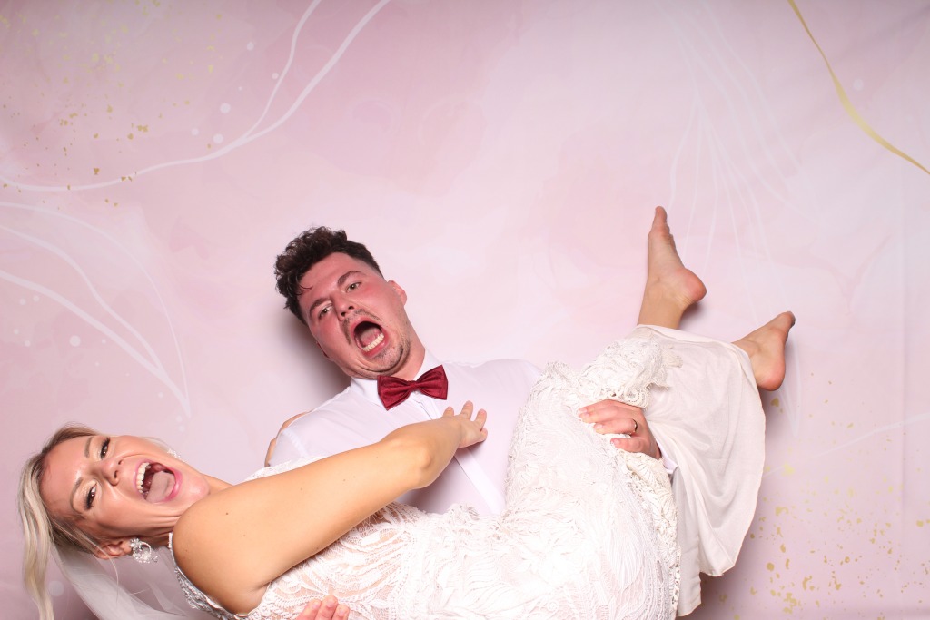 Ženích a nevesta s rekvizitami sa bavia v svadobnej fotobúdke na Liptove.